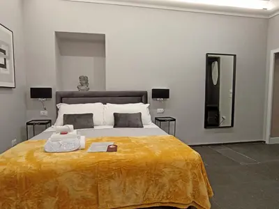 a bedroom with a large bed with a yellow blanket at AD Vatican Luxury Rooms - by AD Roma in Rome