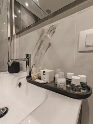 a bathroom sink with a shelf with toiletries on it at AD Vatican Luxury Rooms - by AD Roma in Rome