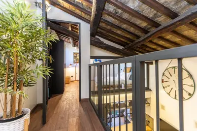 a room with a clock on the wall and a balcony at Mou Trastevere House by Rental in Rome in Rome