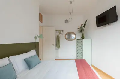 a bedroom with a bed and a tv on the wall at iFlat Cozy flat with a view in San Giovanni in Rome