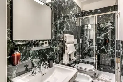 a bathroom with a sink and a toilet and a mirror at Dimore Paganica in Rome