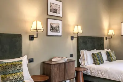 a hotel room with a bed and a table and lights at Dimore Paganica in Rome