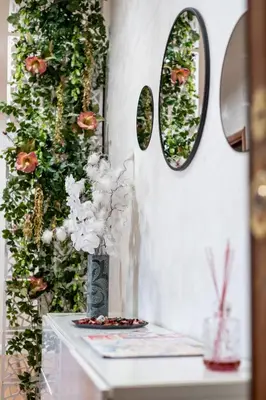 a vase of flowers on a table with mirrors at INTERNO 39 - San Pietro in Rome