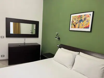 a bedroom with a white bed and a mirror at Vatican Museum Scipioni BED & Breakfast in Rome