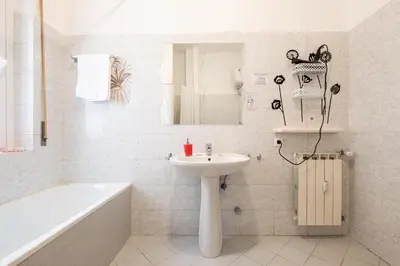 a white bathroom with a sink and a bath tub at Take It Easy Roma Guest House in Rome