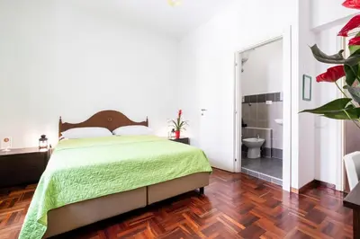a bedroom with a bed and a bathroom with a shower at Take It Easy Roma Guest House in Rome