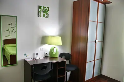 a room with a desk and a chair and a bedroom at Take It Easy Roma Guest House in Rome