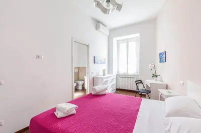 a white room with a large bed with a pink blanket at Apartment Vatican Walls in Rome