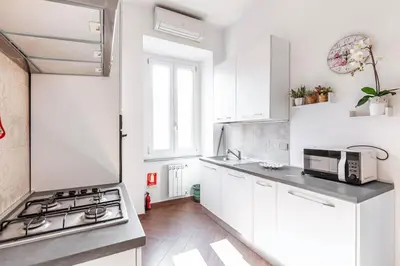 a white kitchen with a stove and a sink at Apartment Vatican Walls in Rome