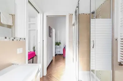 a bathroom with a glass shower and a pink bench at Apartment Vatican Walls in Rome