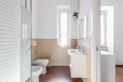 a white bathroom with a toilet and a sink at Apartment Vatican Walls in Rome