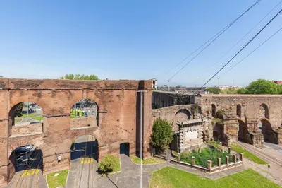 an old brick building with arches on a street at Hostly-ColorHome Rome Midtown in Rome