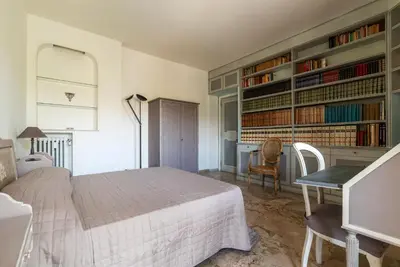 a bedroom with a bed and a desk and bookshelves at GuestHost - 4 Winds Holiday Rental in Rome