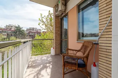a wicker chair sitting on a balcony with a window at GuestHost - 4 Winds Holiday Rental in Rome