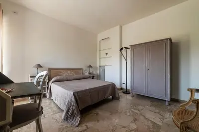 a bedroom with a bed and a table and a chair at GuestHost - 4 Winds Holiday Rental in Rome