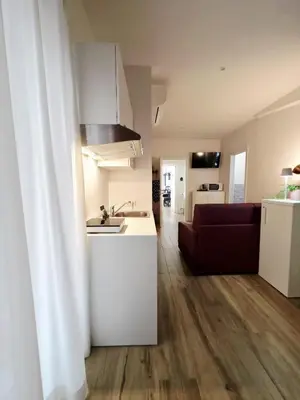 a kitchen and a living room with a red couch at Romi Suite in Rome