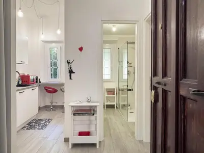 a kitchen with white cabinets and a table with a heart balloon at Appartamento per 4 persone a Garbatella - My Garba in Rome