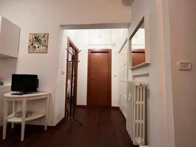a hallway with a door and a desk with a television at Casina Dacia in Rome