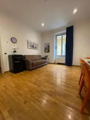 a living room with a couch and a wooden floor at La Stamperia in Rome