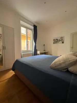 a bedroom with a large blue bed with a window at La Stamperia in Rome