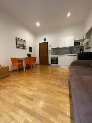 a living room with a table and chairs and a kitchen at La Stamperia in Rome
