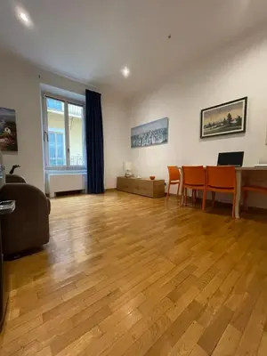 a living room with a wooden floor and a table and chairs at La Stamperia in Rome