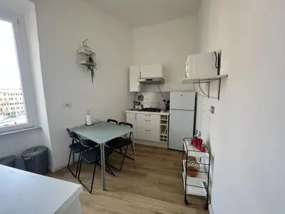 a small kitchen with a table and a refrigerator at interno 18 penthouse in Rome