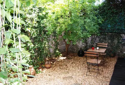 a table and a chair in a garden at TWO-ROOM Apt. under the Aqueduct's ARCH in Pigneto in Rome