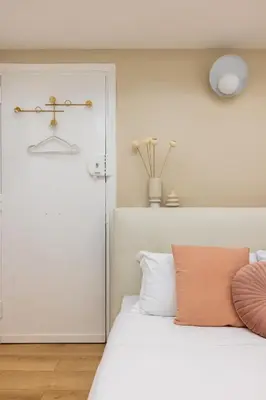 a bedroom with a white bed with a orange pillow at Leonina Apt - Colosseum in Rome
