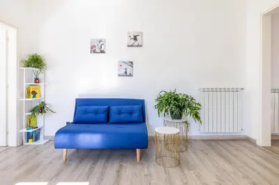 a blue couch in a white room with plants at Maison Blu - in Trastevere in Rome
