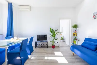 a living room with blue chairs and a table at Maison Blu - in Trastevere in Rome