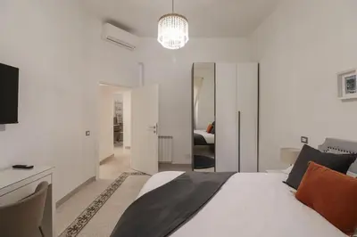 a white bedroom with a bed and a television at Vaticano - appartamento nuovo in Rome