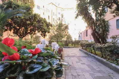 a garden with red flowers on a sidewalk at Vaticano - appartamento nuovo in Rome
