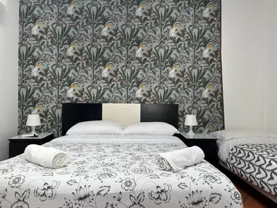 a bedroom with a bed with a floral wallpaper at Casa Felice a piazza Zama in Rome