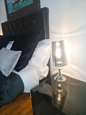 a bedroom with a bed with a glass table with a lamp at Apartment luxury Archimede 80 in Rome