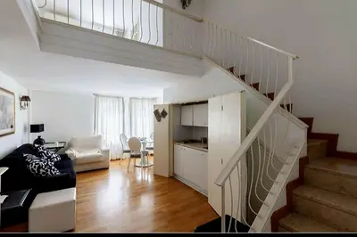 a living room with a staircase with a couch and a table at Apartment luxury Archimede 80 in Rome