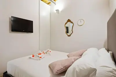 a bedroom with a bed with a mirror and a tv at HostMe Piazza Navona Apartament in Rome
