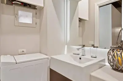 a white bathroom with a sink and a mirror at HostMe Piazza Navona Apartament in Rome