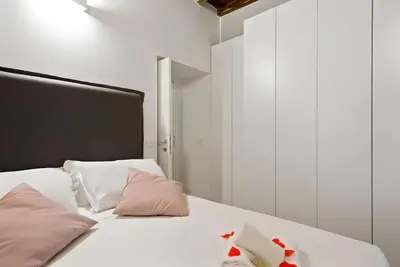 a bed with white sheets and pink pillows at HostMe Piazza Navona Apartament in Rome