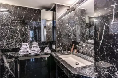 a black marble bathroom with a sink and a mirror at Domus Mondrian Luxury House in Rome