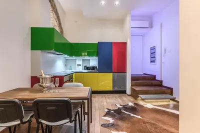 a kitchen with colorful cabinets and a table and chairs at Domus Mondrian Luxury House in Rome