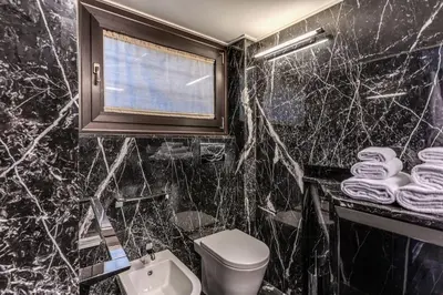 a black marble bathroom with a toilet and a window at Domus Mondrian Luxury House in Rome