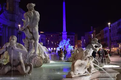 a fountain with statues in a city at night at Boezio43B&B in Rome