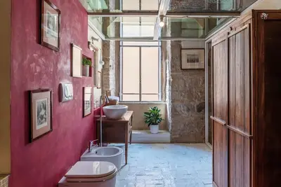 a bathroom with a pink wall with a sink and a toilet at Amazing & Romantic *Loft Testaccio Aventino* in Rome