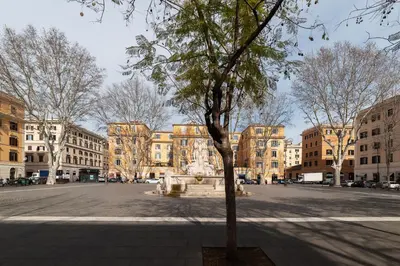 a tree in the middle of a street with buildings at Amazing & Romantic *Loft Testaccio Aventino* in Rome