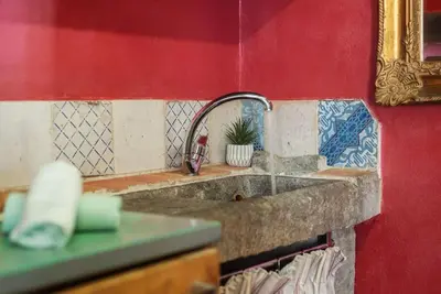 a kitchen counter with a sink and a red wall at Amazing & Romantic *Loft Testaccio Aventino* in Rome