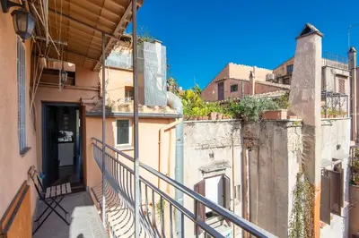 a balcony of a building with a door and buildings at Panoramic Apartment Trastevere in Rome