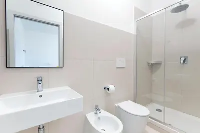 a bathroom with a sink and a toilet and a mirror at Luciano San Giovanni Guest House in Rome