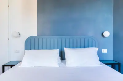 a blue bedroom with a bed with two white pillows at Luciano San Giovanni Guest House in Rome