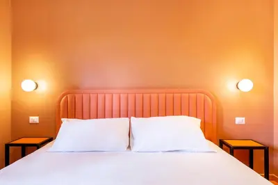 a bed with two pillows and two night stands at Luciano San Giovanni Guest House in Rome